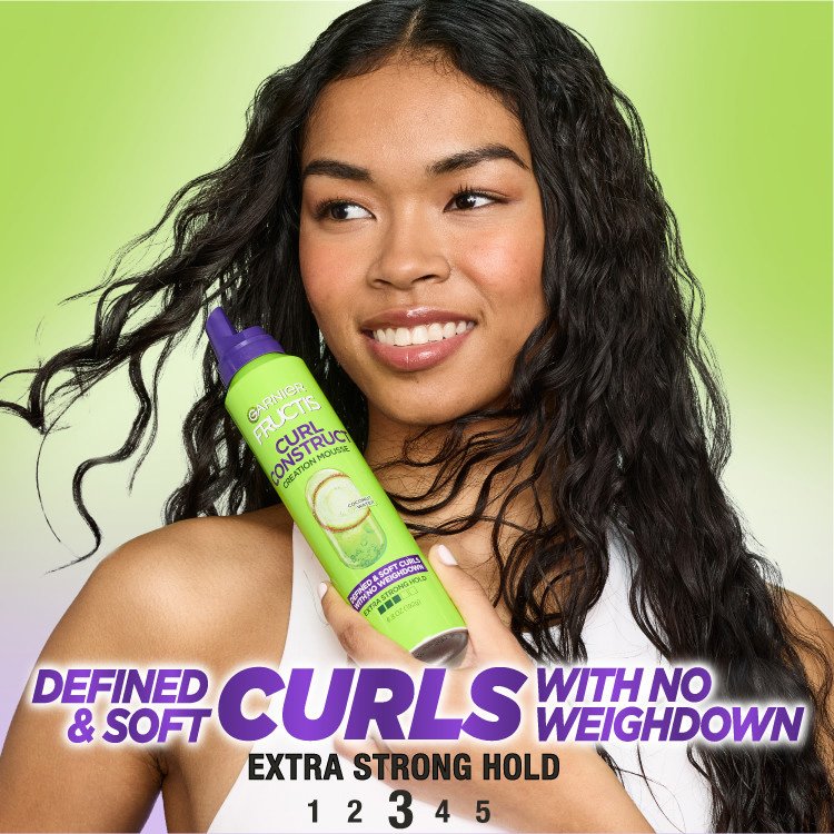 Woman with defined, soft curls and Garnier Fructis Creation Mousse.
